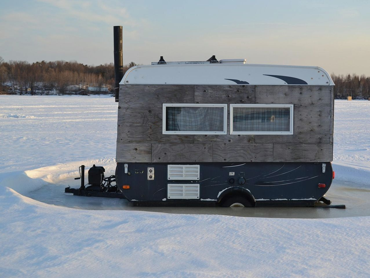 Cabaña de madera con equipos de pesca en el hielo